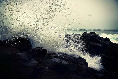 transportation grayscale photography of ocean waves crashing on rock during daytime vehicle